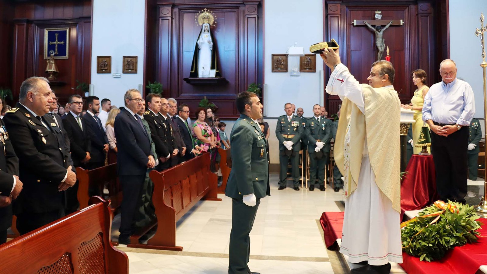 Foto de grupo de los agentes de la Guardia Civil con sus familias y el alcalde Toni Pérez en la iglesia de la Almudena