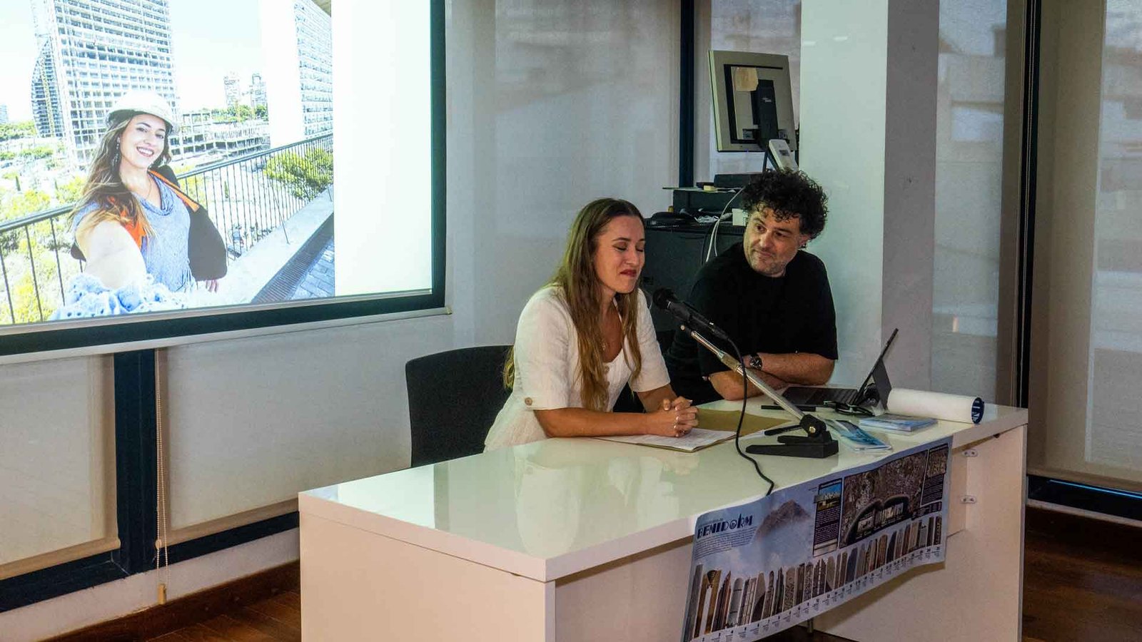 La ingeniera Sofía Escortell interviene en la presentación, con el póster comparativo de torres al frente de la mesa